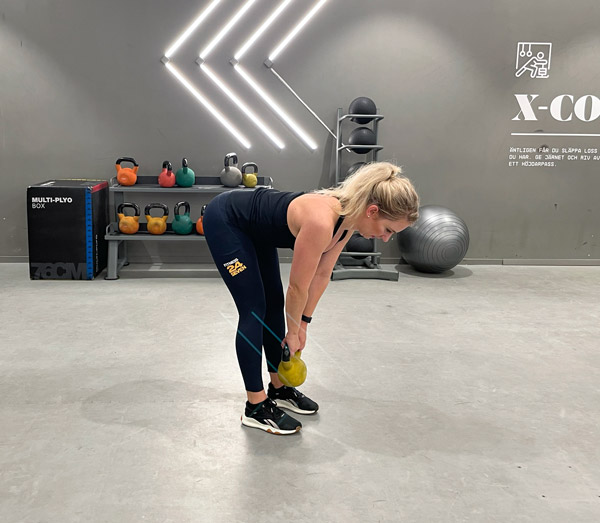 Kvinna gör marklyft med kettlebell