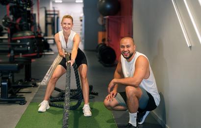Två glada medlemmar går på ett HYROX pass på Fitness24Seven